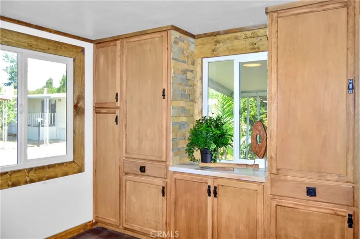 Big, Beautiful Kitchen with New Cabinetry, Quartz Countertops, Stainless Steel Sink with Sprayer, Stainless Steel and Black Range, Wood and Stone Accents, Custom Lighting, Black Hardware, and a Wood-Trimmed Refrigerator