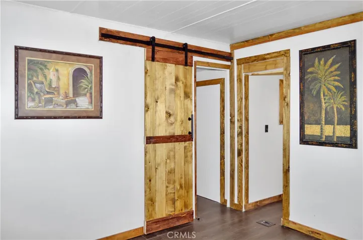 The Main Bedroom Next Door has a Barn Door Entry, Modern Lighting, Dual Closets with Drawers Below, and More Storage Hidden Behind the Barn Door