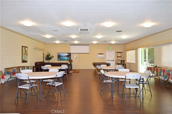 Inside the clubhouse, there's a pool table, cozy lounge area, dining tables, full kitchen and activities to enjoy with new friends (TV screen simulated)