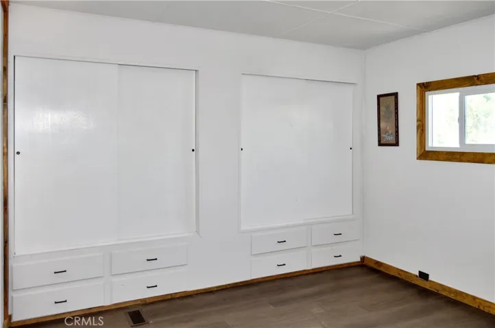The Main Bedroom Next Door has a Barn Door Entry, Modern Lighting, Dual Closets with Drawers Below, and More Storage Hidden Behind the Barn Door