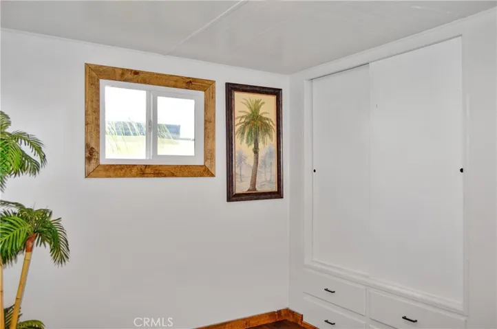 The 2nd Bedroom is Accessed via the Main Bedroom and Offers More Closet Space with Drawers Below, Hook-ups for a Stackable Washer/Dryer, and Another Sliding Entry Door