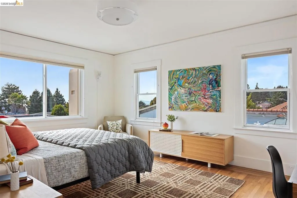 Hardwood flooring, white painted walls, multiple windows, built-in ceiling light fixture, and a built-in wood-finish console Hardwood flooring, white painted walls, multiple windows, built-in ceiling light fixture, and a built-in wood-finish console