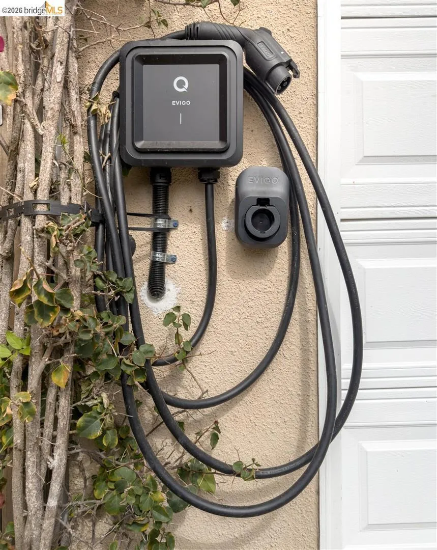 Wall-mounted electric vehicle charging station with integrated cable management Wall-mounted electric vehicle charging station with integrated cable management