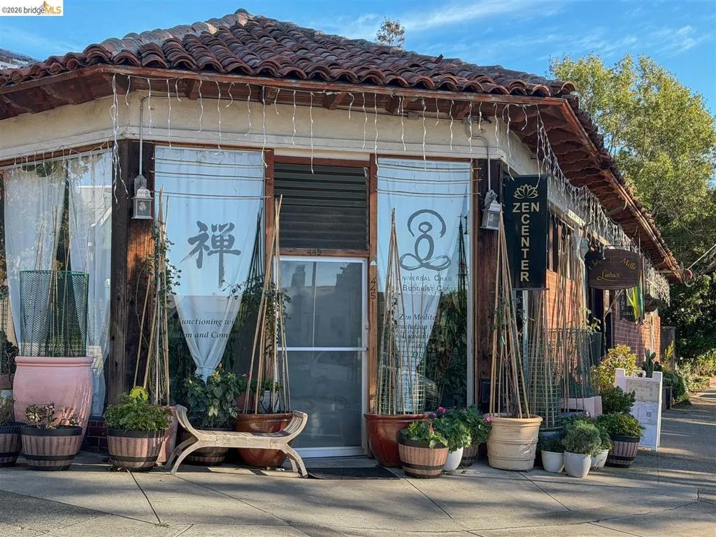 Terracotta tile roofline, exposed wood beams, and a corner storefront with multiple windows Terracotta tile roofline, exposed wood beams, and a corner storefront with multiple windows