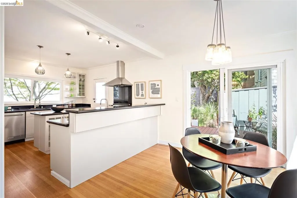 Contemporary kitchen featuring stainless steel appliances, dark countertops, and a central island Contemporary kitchen featuring stainless steel appliances, dark countertops, and a central island