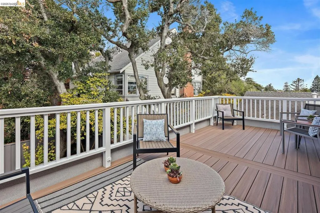 Expansive outdoor deck featuring wood-finish flooring and white railings Expansive outdoor deck featuring wood-finish flooring and white railings