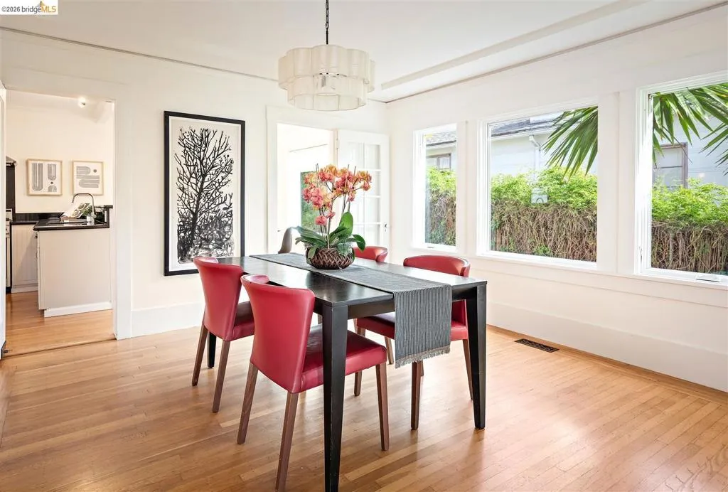 Hardwood flooring and recessed lighting illuminate this dining space featuring multiple windows, a chandelier, and an open entryway to the kitchen Hardwood flooring and recessed lighting illuminate this dining space featuring multiple windows, a chandelier, and an open entryway to the kitchen
