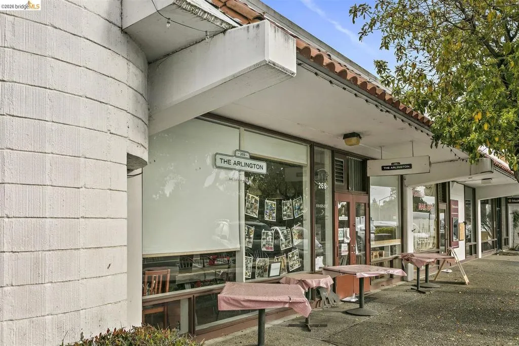 Street-level storefront with large display windows, a double-door entrance, and an overhead sign Street-level storefront with large display windows, a double-door entrance, and an overhead sign