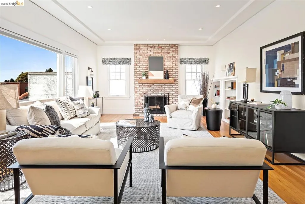Recessed lighting, wood-finish flooring, and a brick-faced fireplace with a wood mantel Recessed lighting, wood-finish flooring, and a brick-faced fireplace with a wood mantel