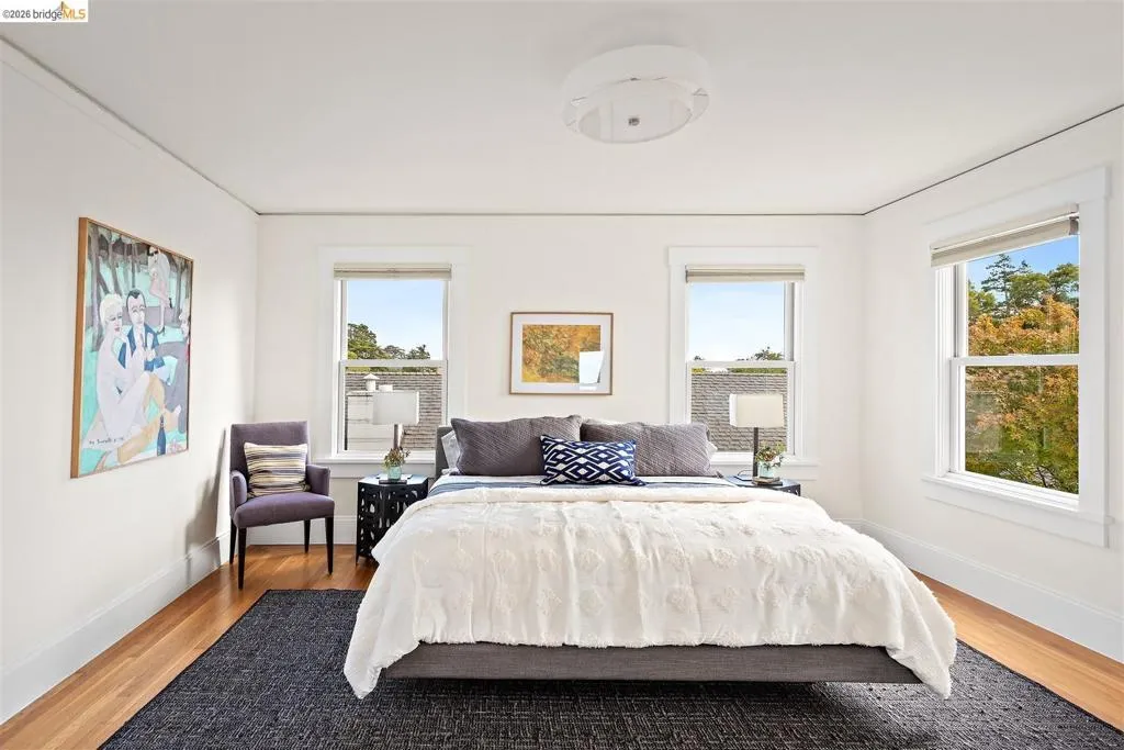 Hardwood flooring, white painted walls, multiple windows, a ceiling-mounted light fixture, and white trim work Hardwood flooring, white painted walls, multiple windows, a ceiling-mounted light fixture, and white trim work