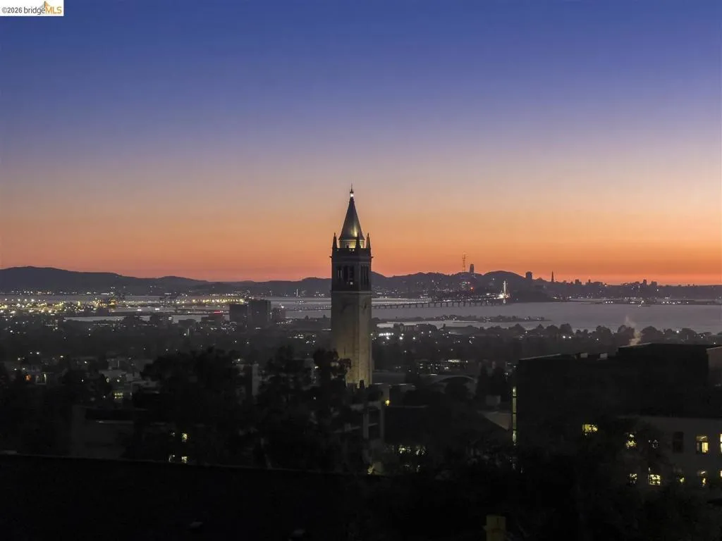 Skyline with a prominent illuminated tower, distant city lights, and expansive water body Skyline with a prominent illuminated tower, distant city lights, and expansive water body