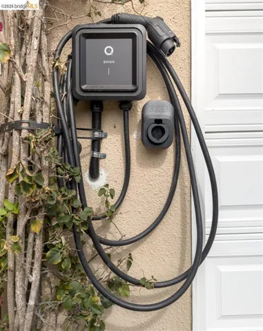Wall-mounted electric vehicle charging station with integrated cable management
