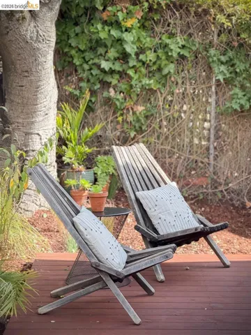 Expansive wood-finish deck with surrounding lush plantings and mature trees