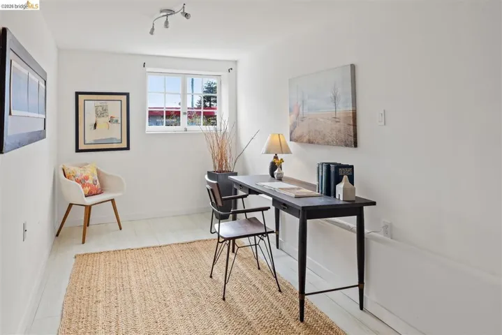 White walls, wood-finish flooring, and a multi-pane window