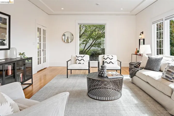 Hardwood flooring, coved ceilings, French doors, and ample natural light from multiple windows