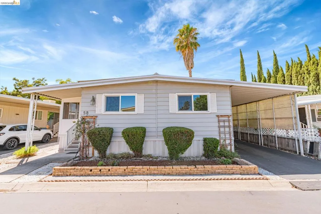 Manufactured / mobile home featuring driveway and a carport