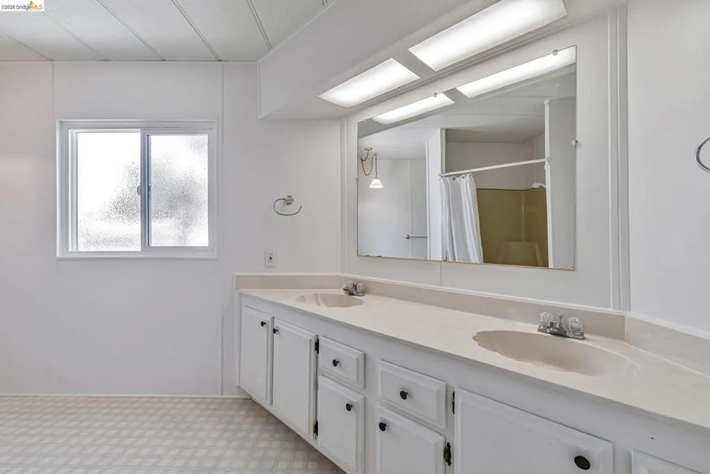 Bathroom with double vanity and a shower with shower curtain