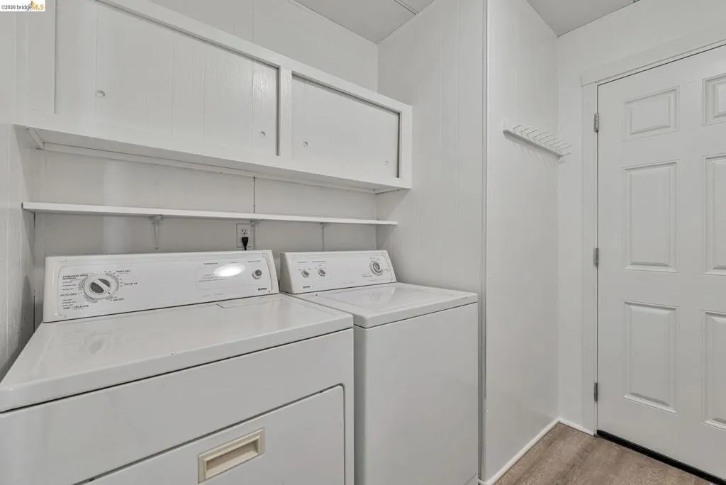 Washroom featuring separate washer and dryer and cabinet space