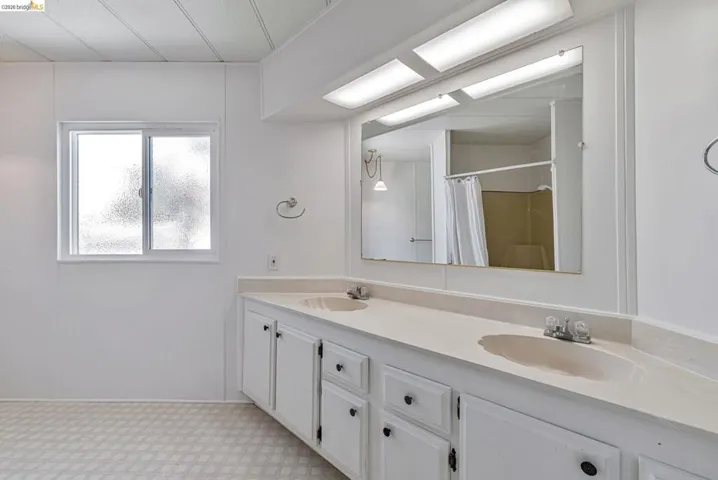 Bathroom with double vanity and a shower with shower curtain