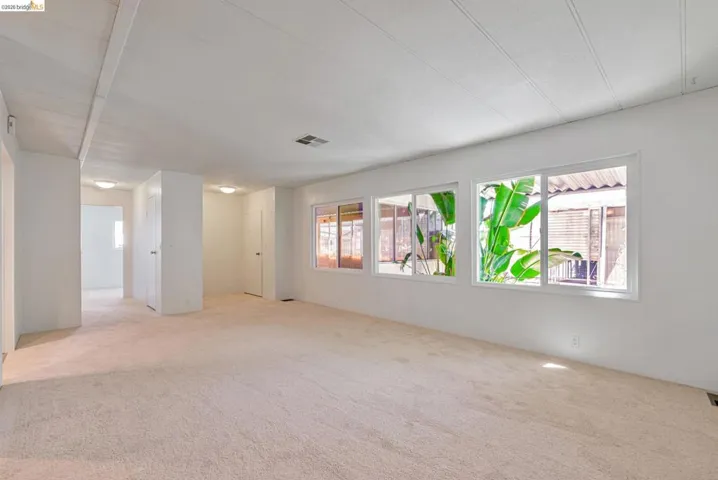 Empty room with plenty of natural light and light colored carpet
