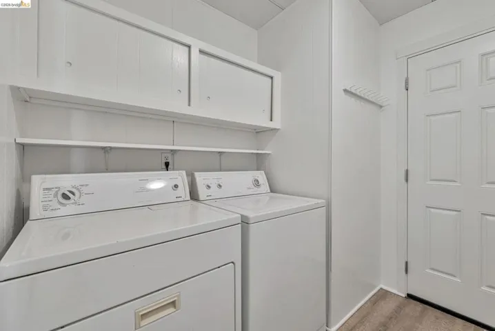 Washroom featuring separate washer and dryer and cabinet space