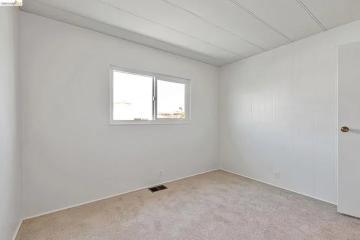 Unfurnished room featuring light carpet and baseboards