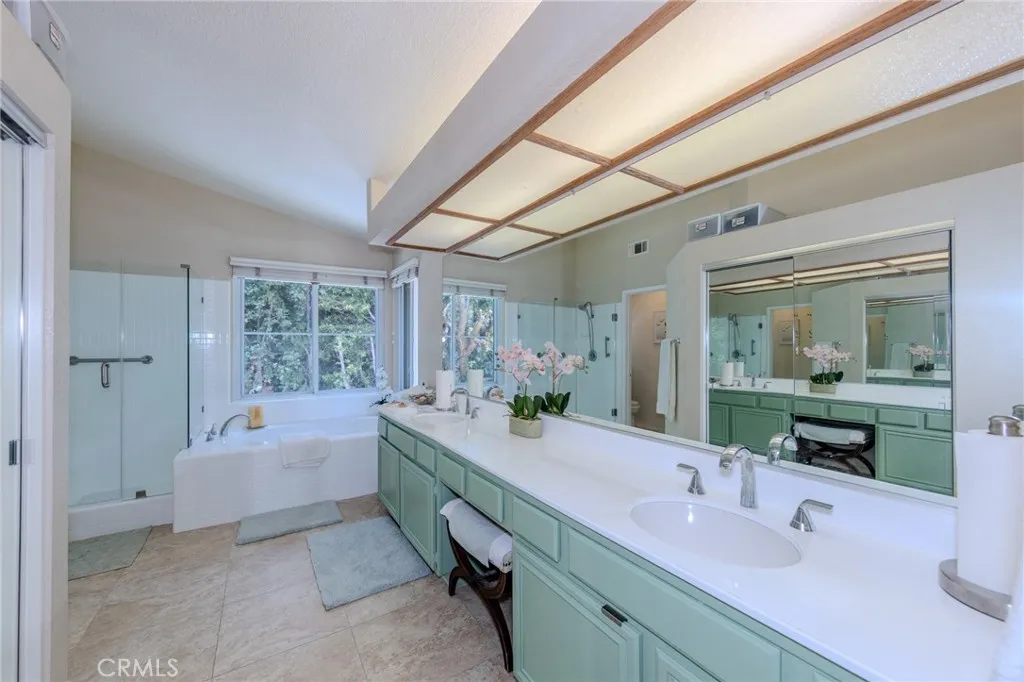 Primary suite private bath with double vanity with make-up desk, large soaking tub, walk-in shower and privacy commode room. Large walk-in closet with mirrored wardrobe doors.