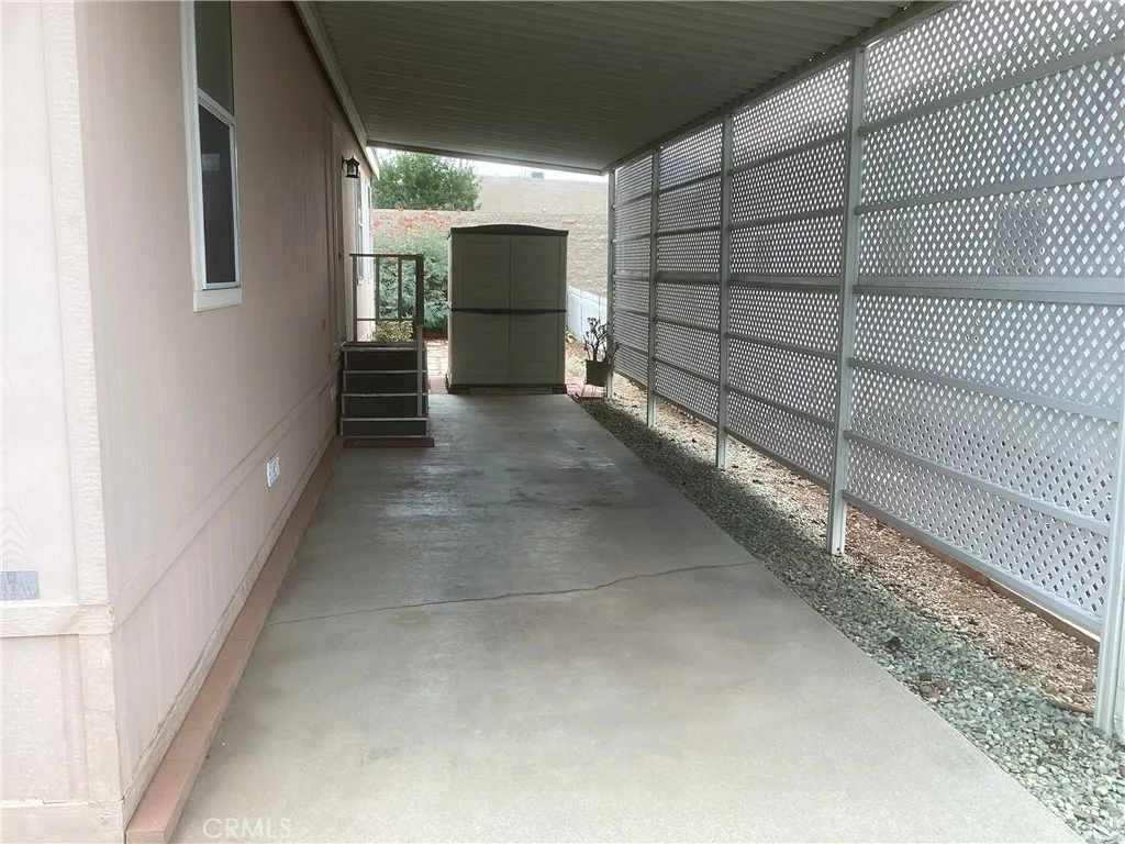 Large car port with a storage shed at the end