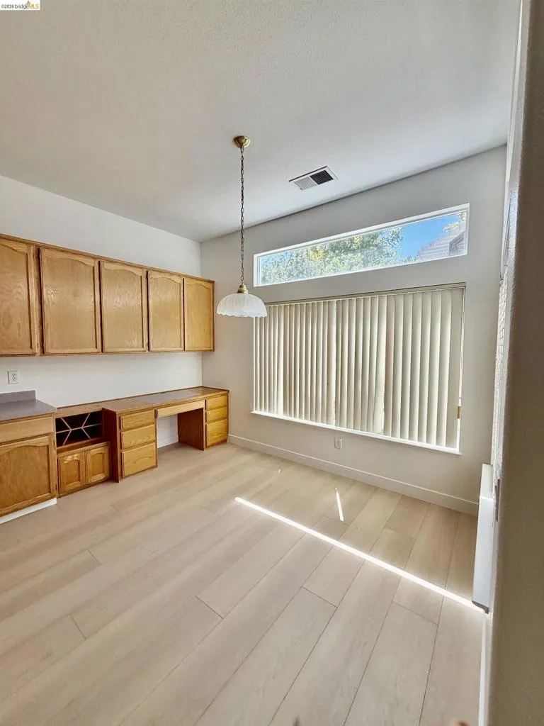 Built-in cabinetry with wood-finish doors, integrated desk, and wine storage