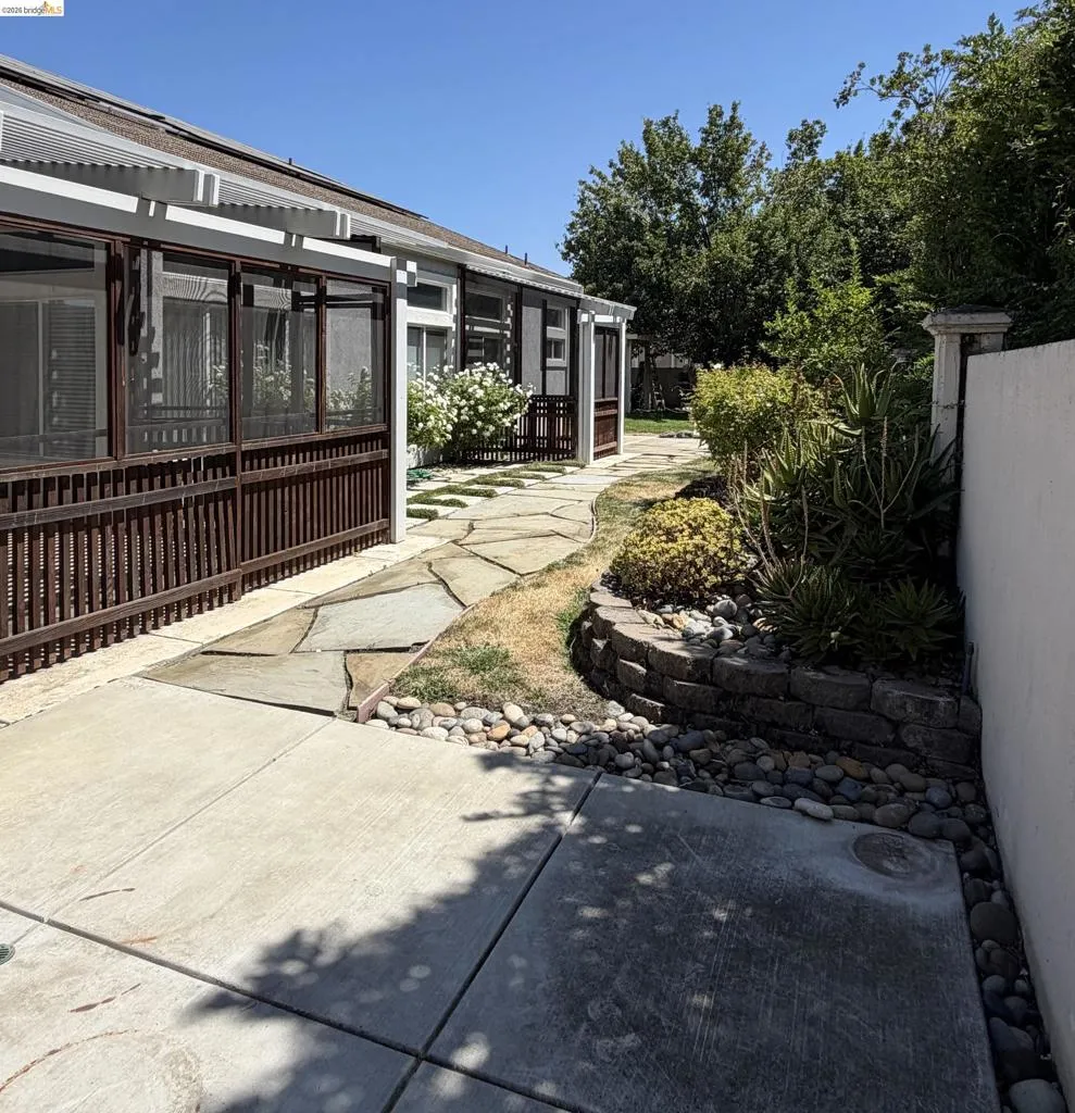 Screened patio enclosure with a slatted privacy wall