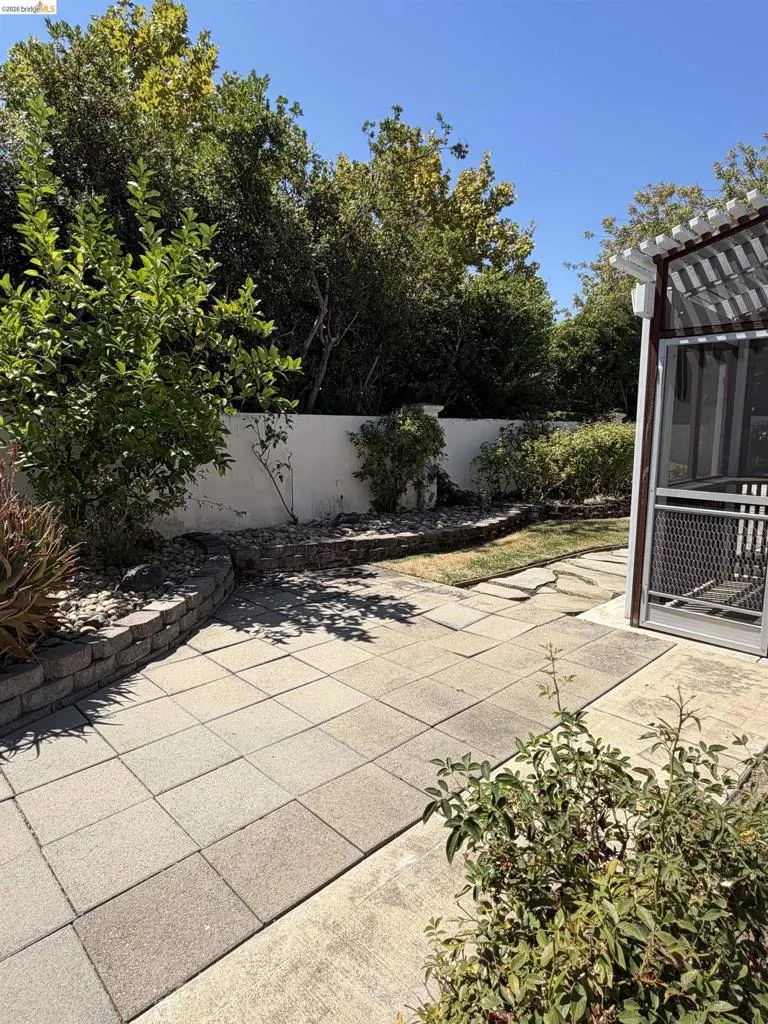 Patio area featuring square pavers and a concrete path