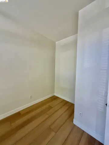 Wood-finish flooring with white baseboards, complemented by neutral wall tones