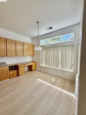 Built-in cabinetry with wood-finish doors, integrated desk, and wine storage