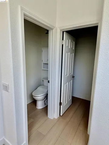Wood-finish flooring with white trim and paneled doors