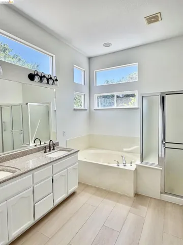Dual vanity with integrated sinks, light-toned countertop, and white cabinetry