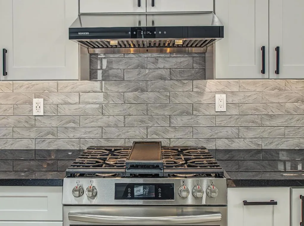 Stove has Griddle Pan and modern hood vent. Stove has Griddle Pan and modern hood vent.