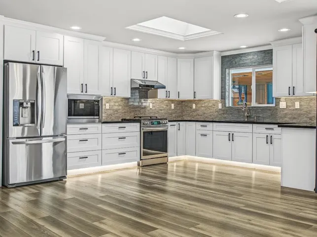 Gorgeous Kitchen with Recess lighting on ceiling, top and bottom of cabinets. Natural light-Skylight