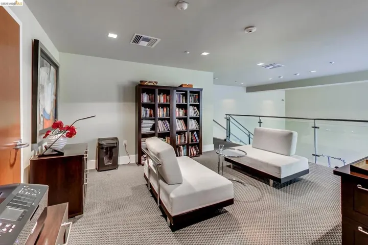 Living area with an upstairs landing and light carpet