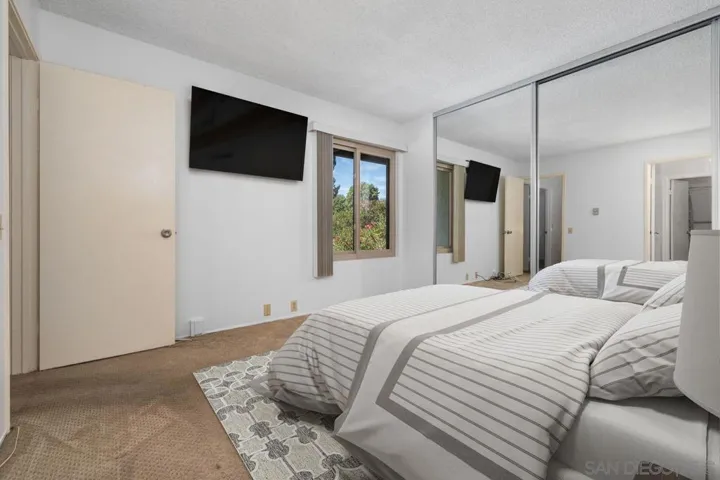 Primary bedroom with flat-screen TV bracket.  Virtually staged.