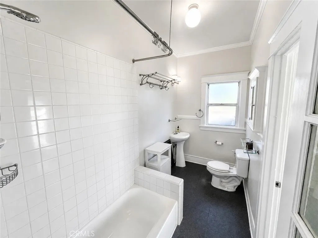Bathroom with Reglazed tub, shower, pedestal sink and Storage.