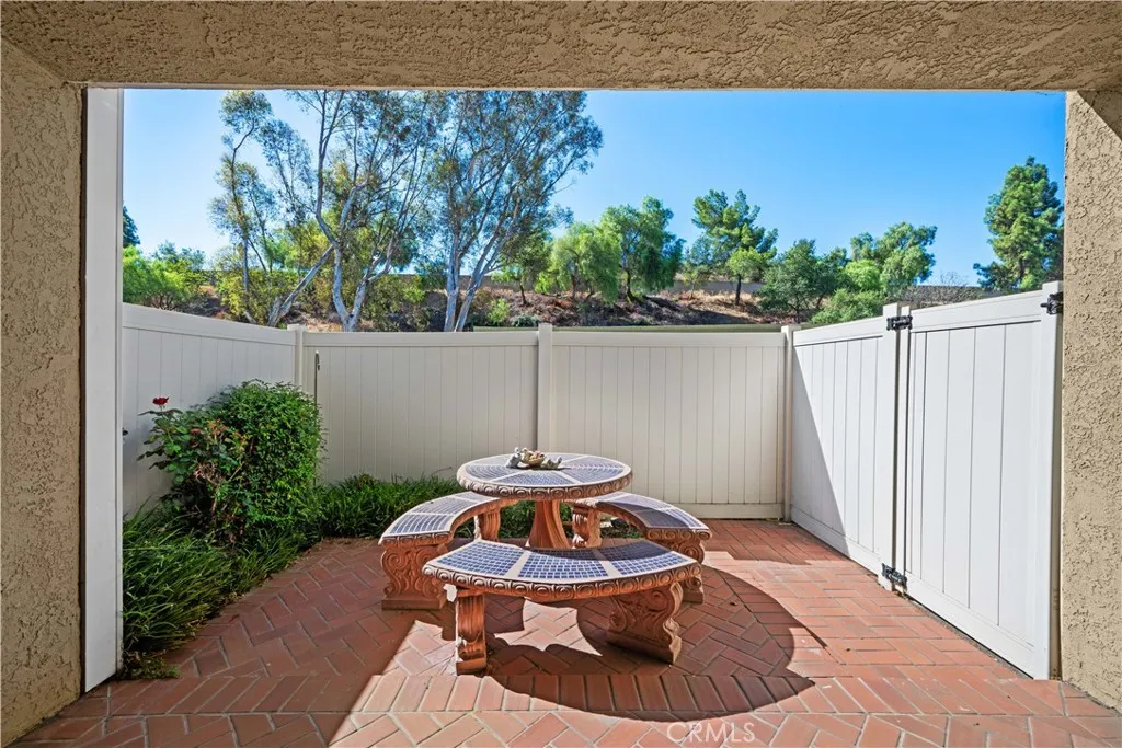 Private, fenced patio with green hillside view