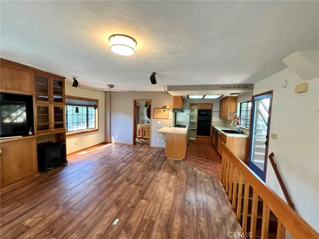 Main floor living area, with kitchen and bath in the far end of the room. Kitchen glass door on right leads around to the deck off the living room