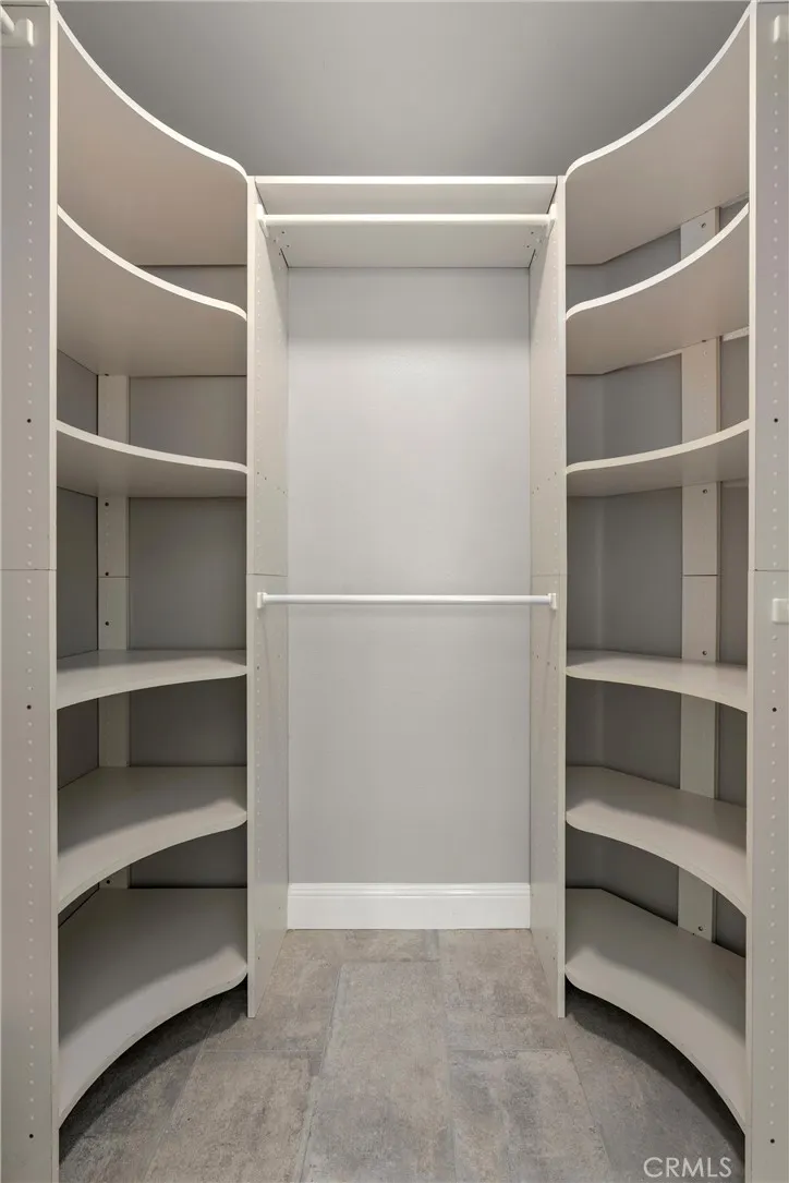 Walk-in closet with built-in shelving and hanging storage.