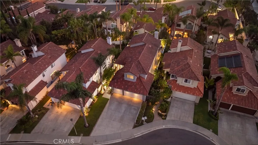 Aerial view showcasing the home within the beautifully landscaped community and surrounding hills.