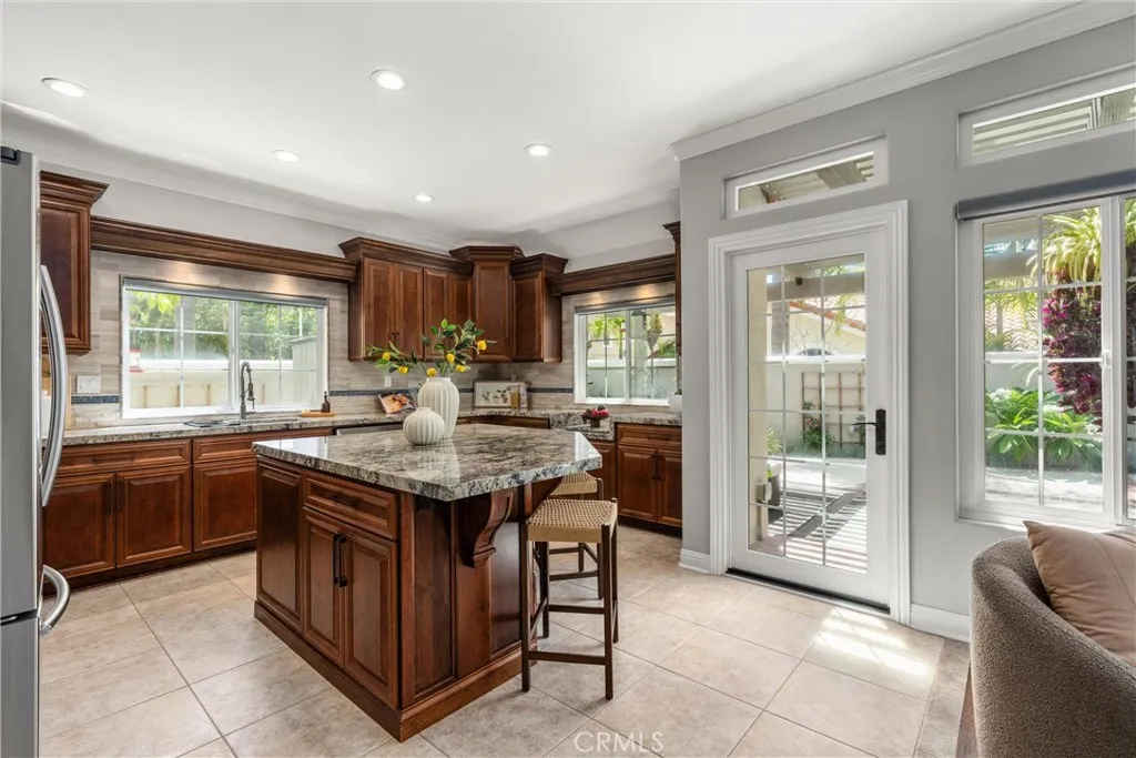 Spacious kitchen with custom wood cabinetry, granite countertops, center island and stainless steel appliances.