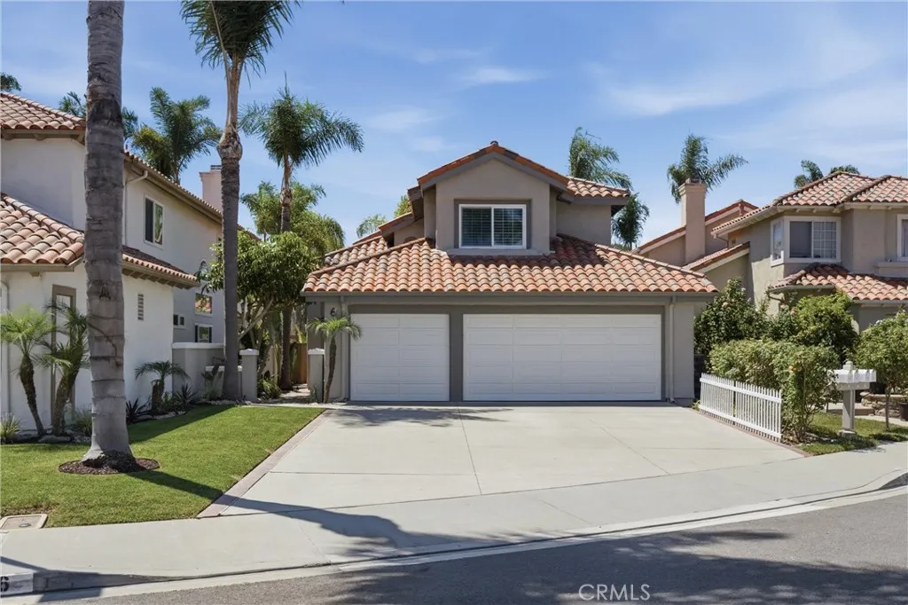 Inviting curb appeal with a spacious driveway, three-car garage, and manicured lawn.