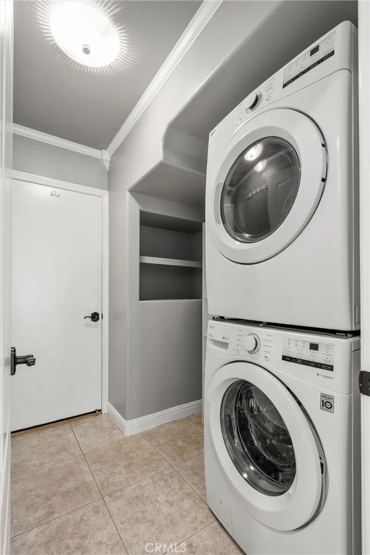 Convenient laundry area with stacked washer and dryer and built-in storage.