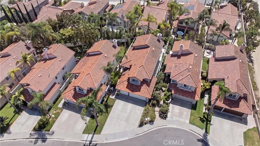 Aerial view showcasing the home within the beautifully landscaped community and surrounding hills.