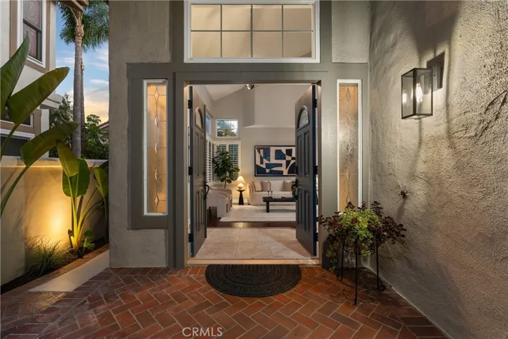 Inviting brick-lined entry walkway surrounded by lush tropical landscaping.