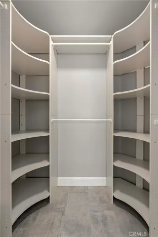 Walk-in closet with built-in shelving and hanging storage.